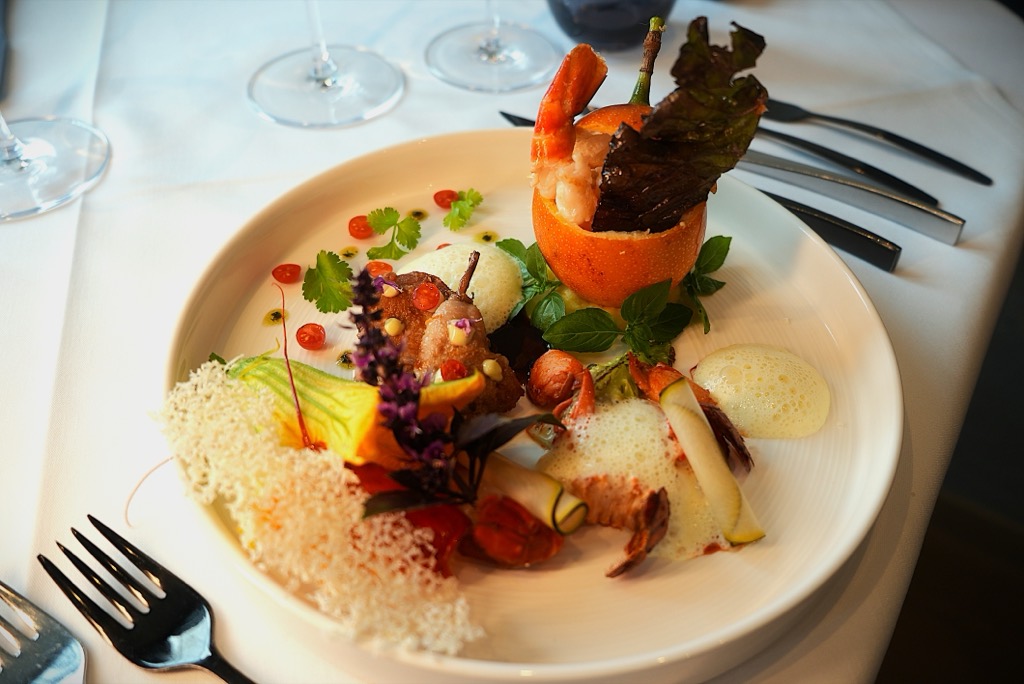 Gang mit Garnele, Zucchiniblüte und Kräutern