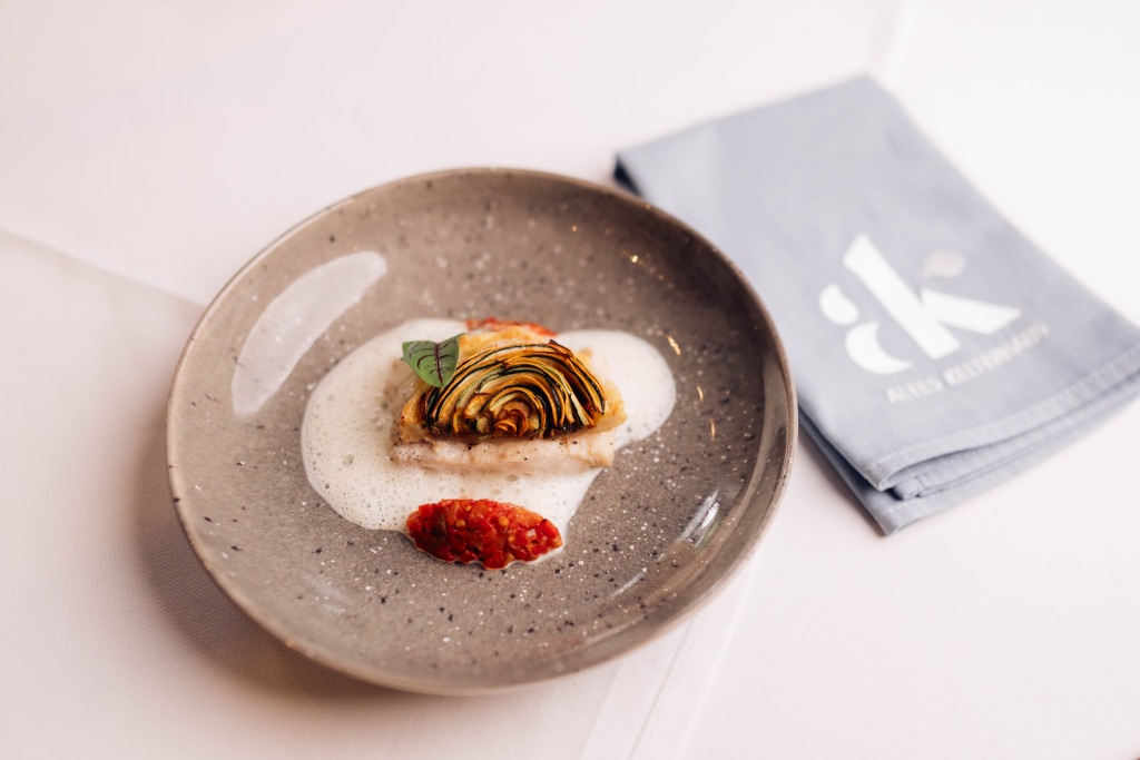 Plated course on a grey plate, with a logo napkin beside it