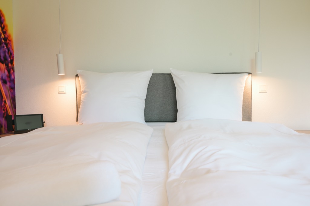 Lit fraîchement fait dans une suite avec une fresque de lavande